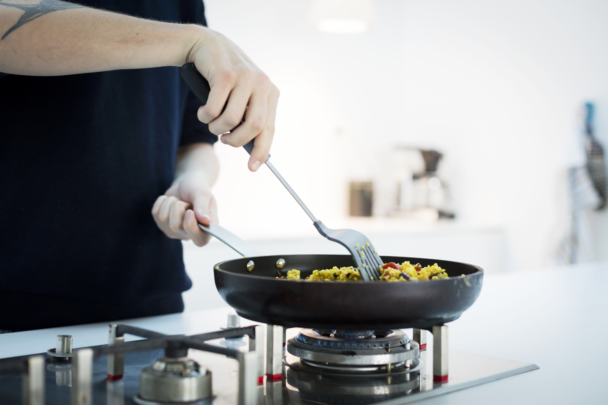 Mid section of man cooking food in kitchen