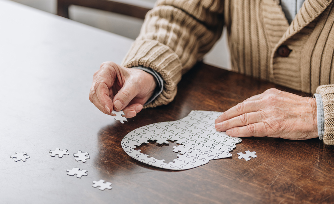 cropped view of senior man playing with puzzles