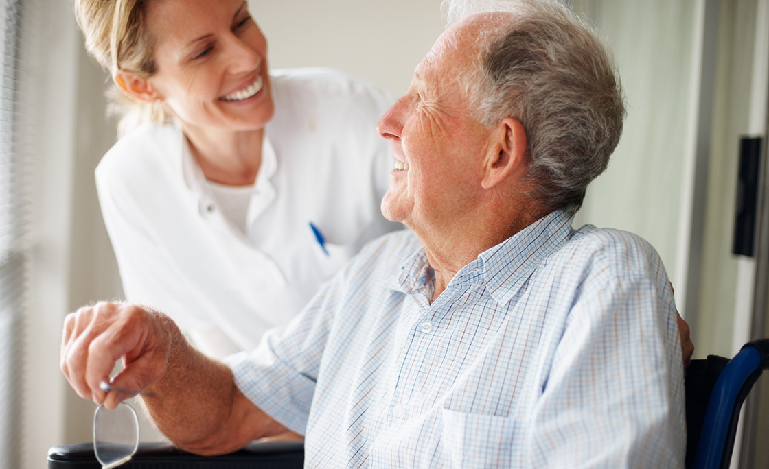Elderly man speaking to a nurse