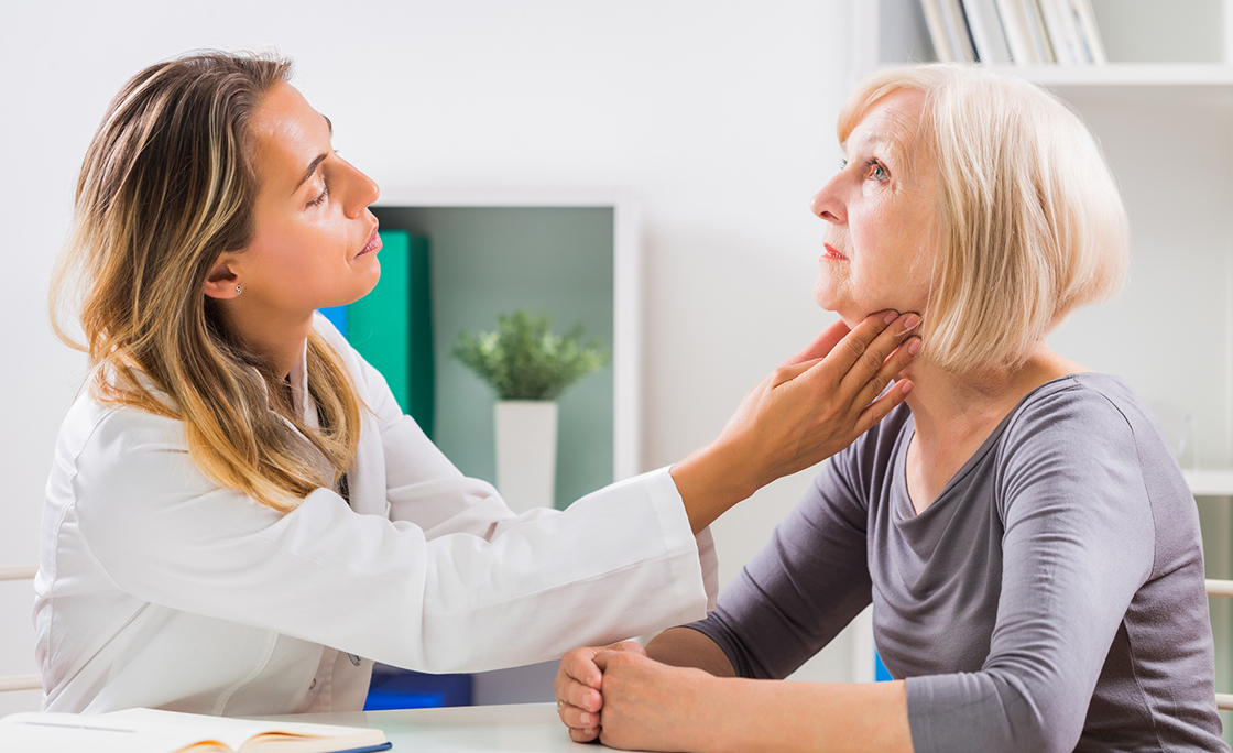 Doctor examines patient’s throat