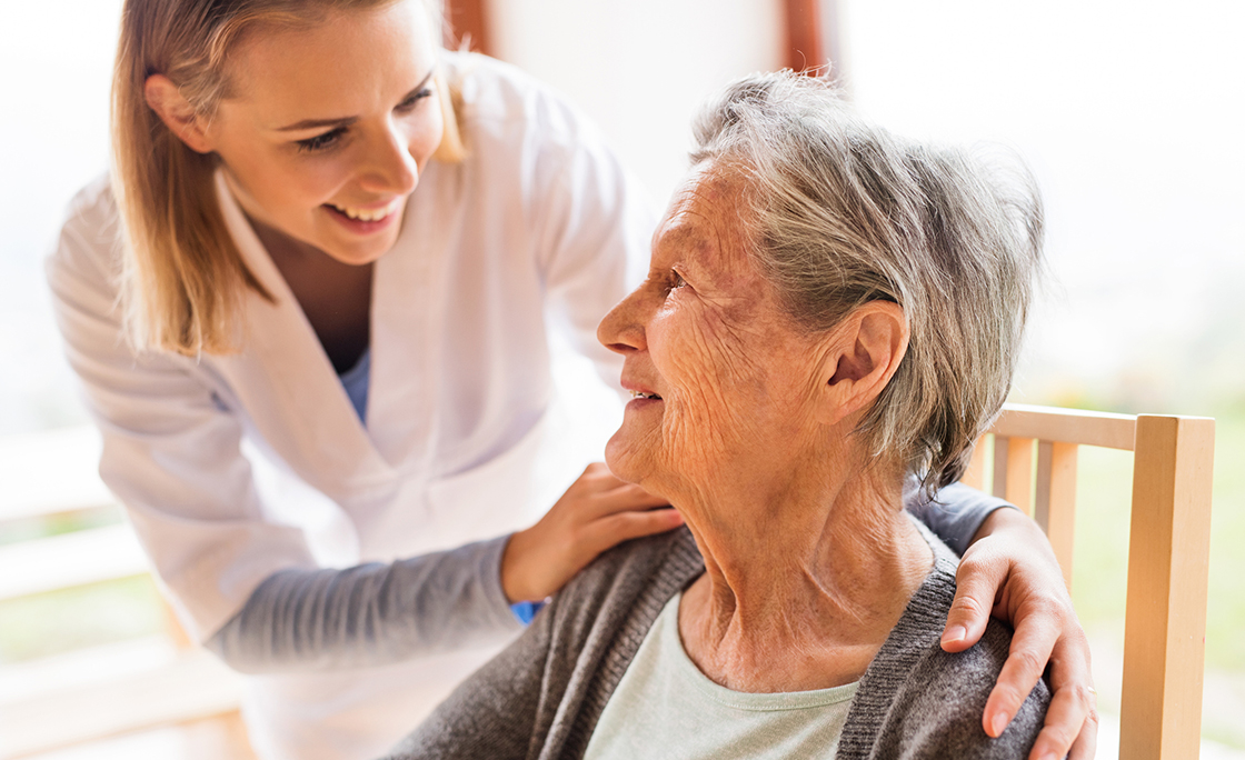 Health visitor and a senior woman during home visit.