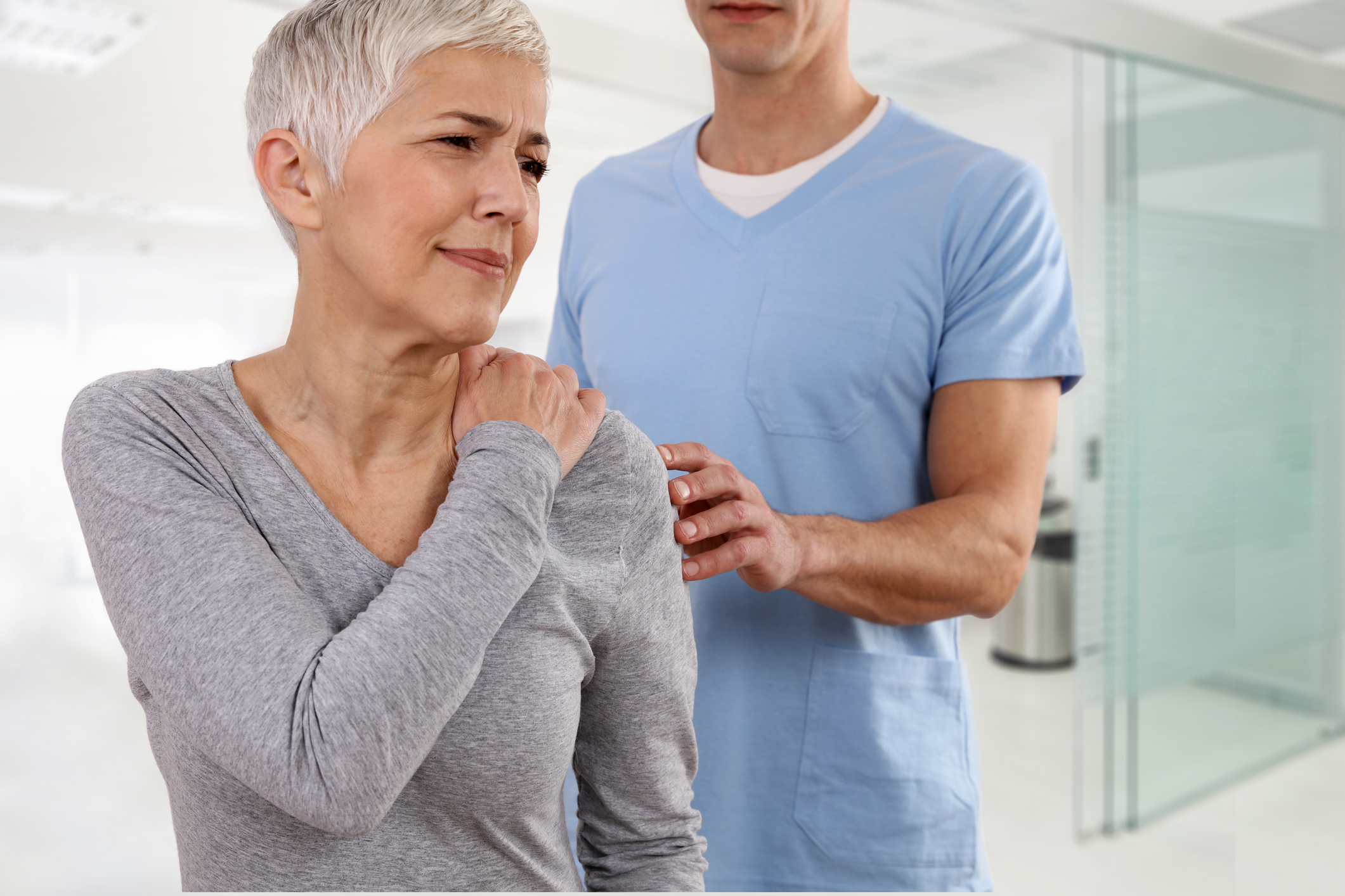Mature Woman suffering from back pain during medical exam. Chiropractic, osteopathy, Physiotherapy. Alternative medicine, pain relief concept.