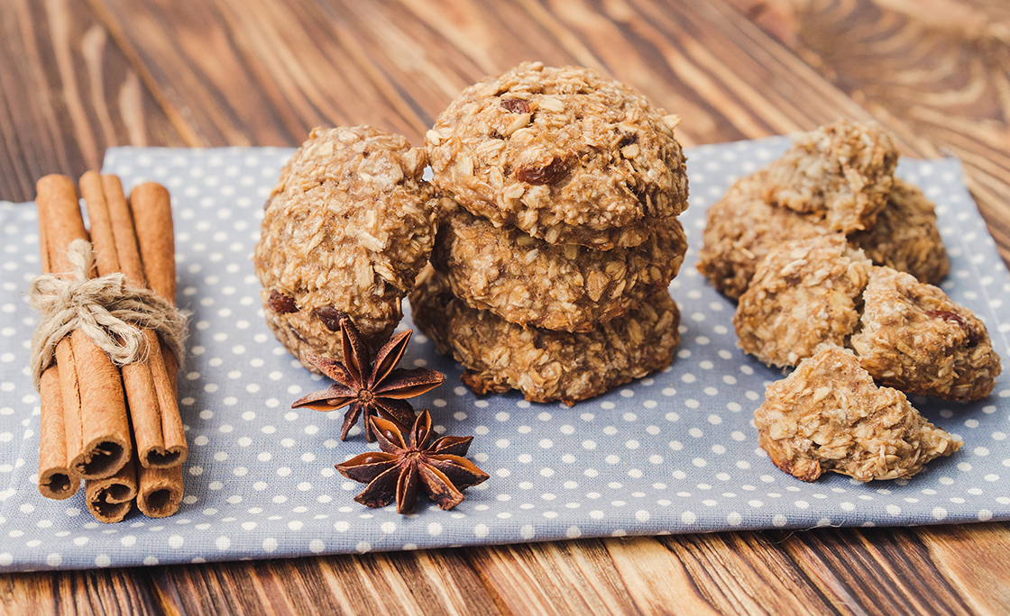 Oatmeal and banana cookies and spices on brown wooden table.