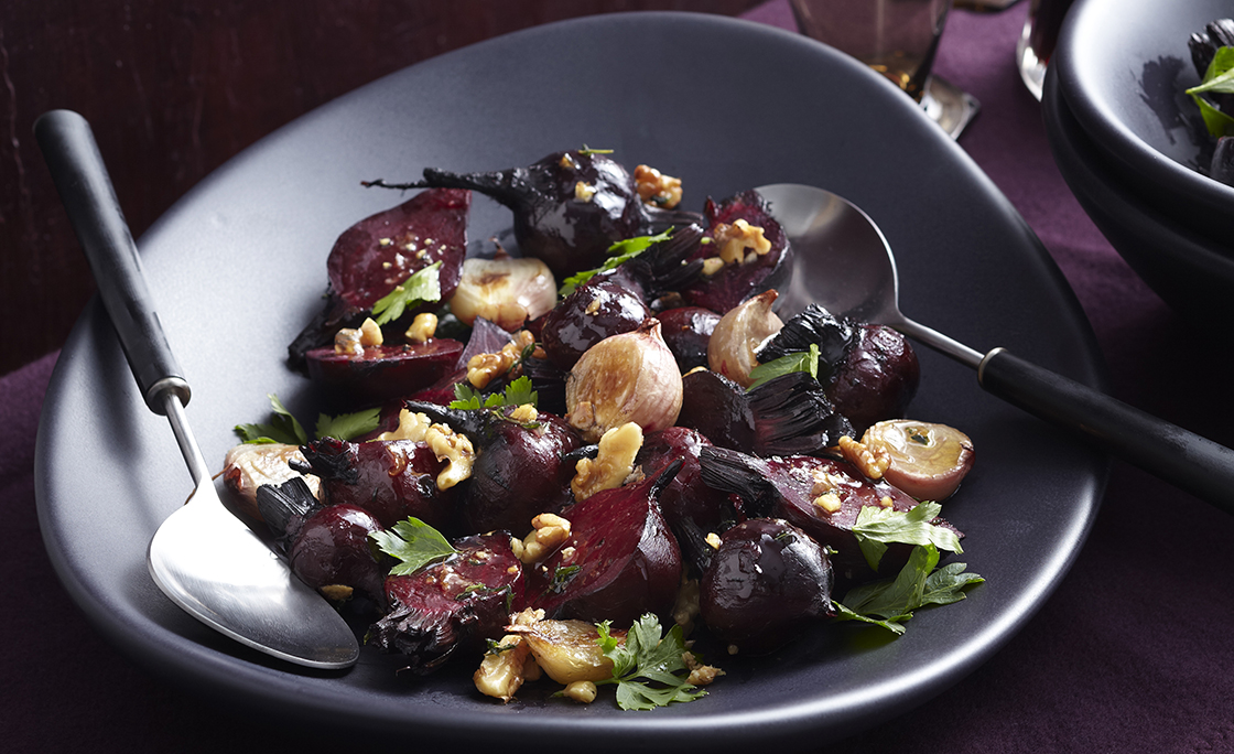 Bowl of warm beetroot salad on table with red wine