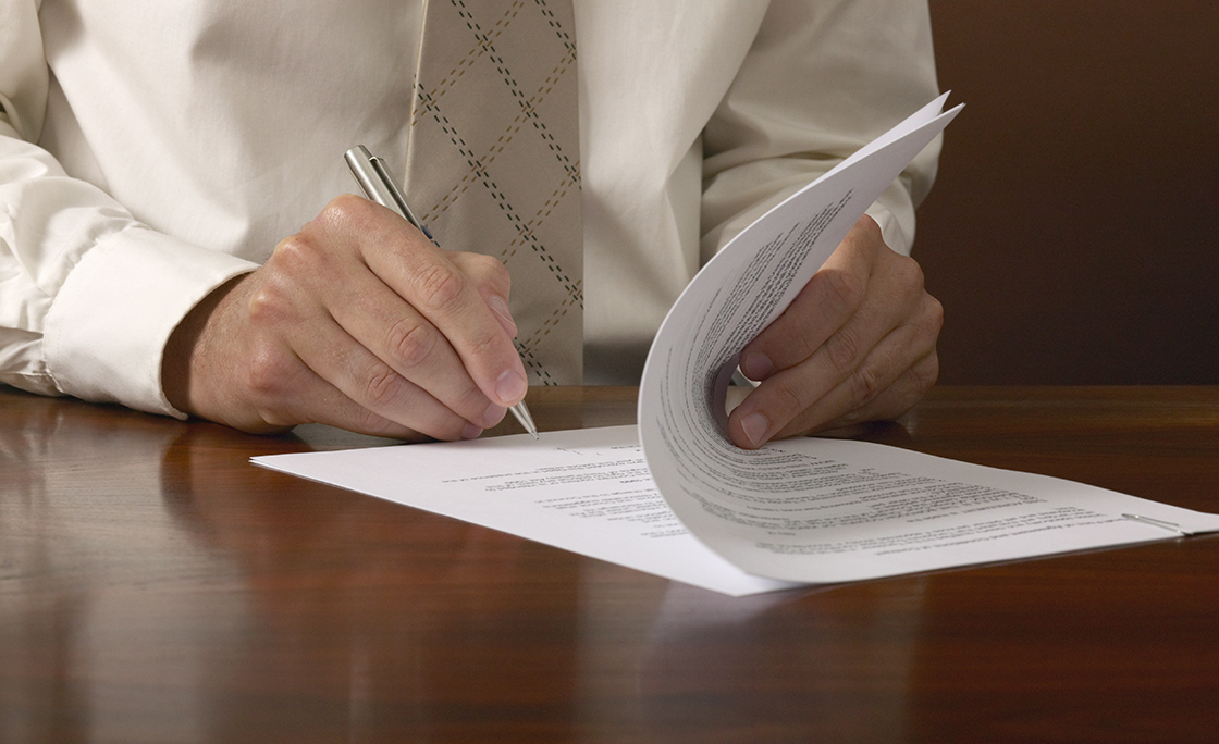 Businessman signing papers on desk, close up, close-up