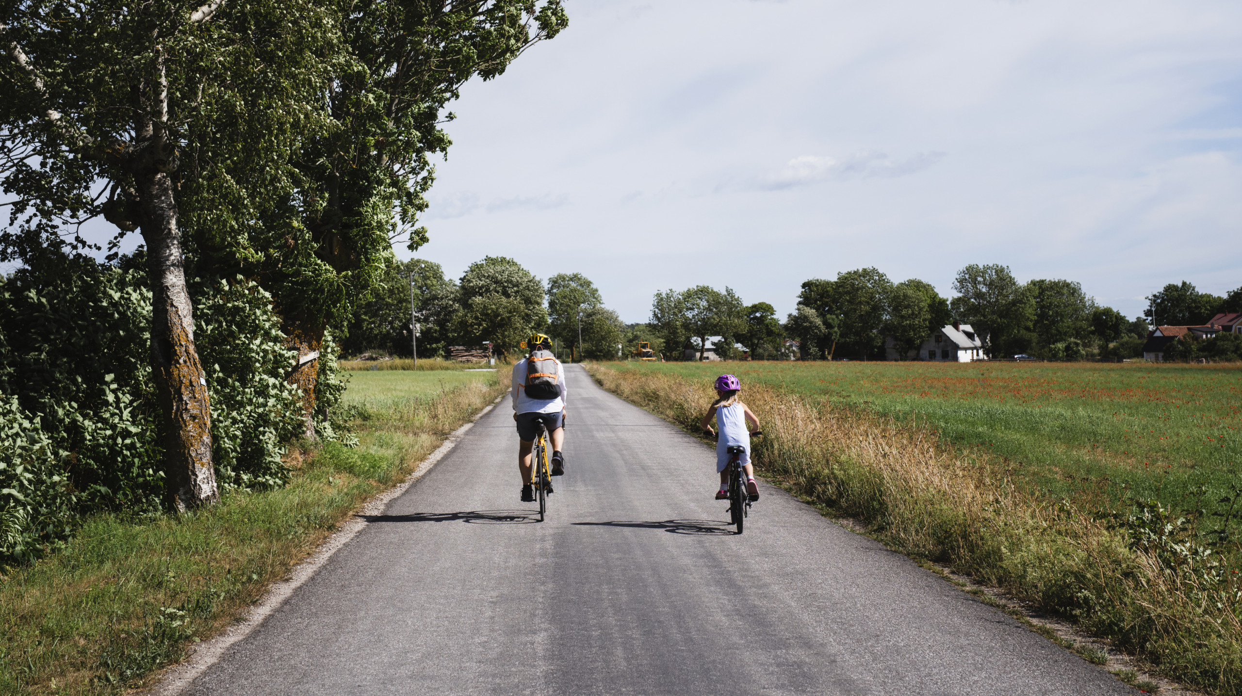 Father and daughter cycling in fields