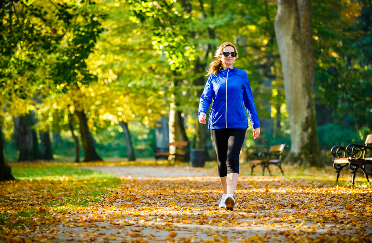 Mid aged woman running in city park