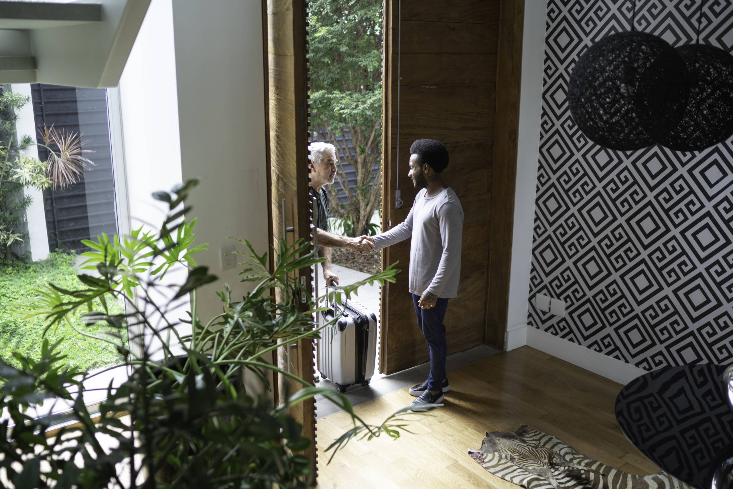 Host welcoming his guest in the entrance hall