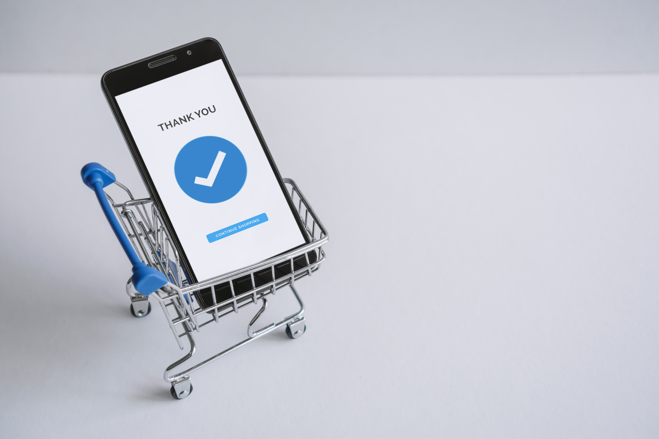 Mobile Phone Inside Shopping Cart. Online Shopping Concept.