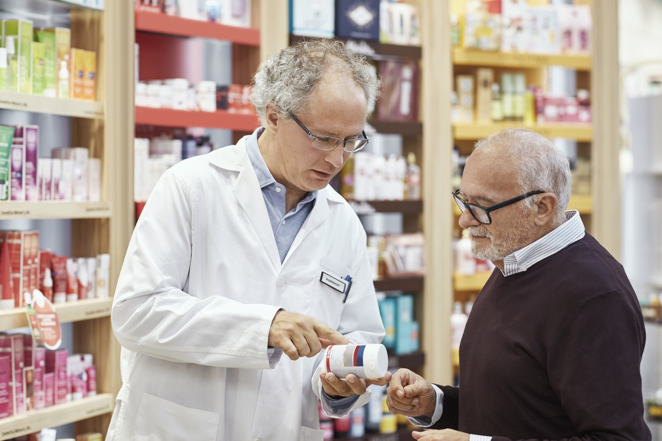 Man listening to sales clerk explaining medicine