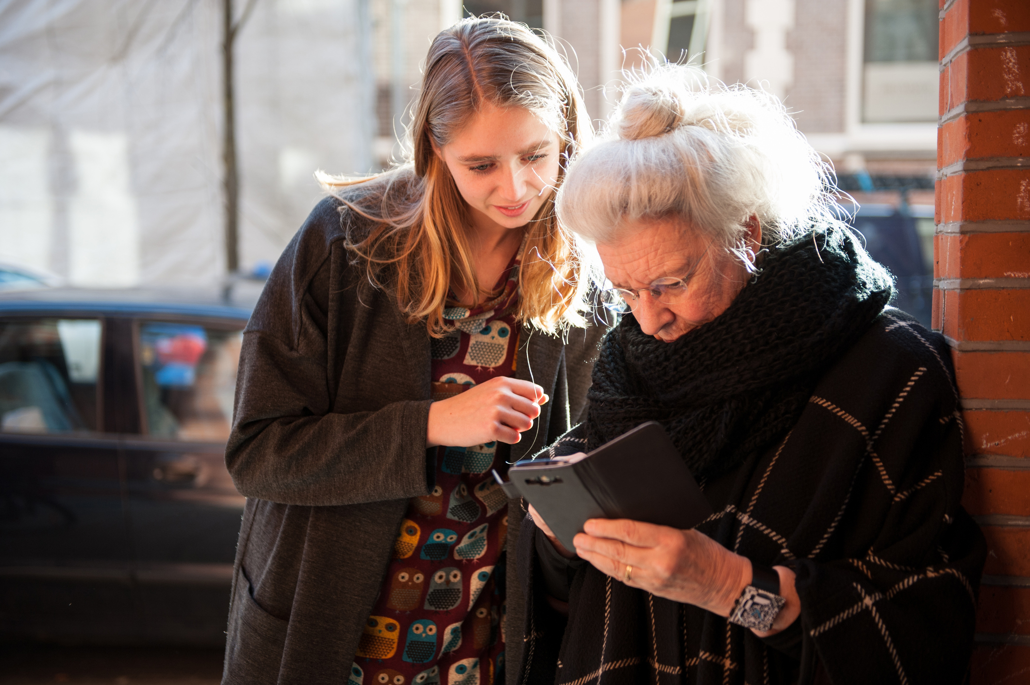 Senior lady and grandchild looking at smartphone