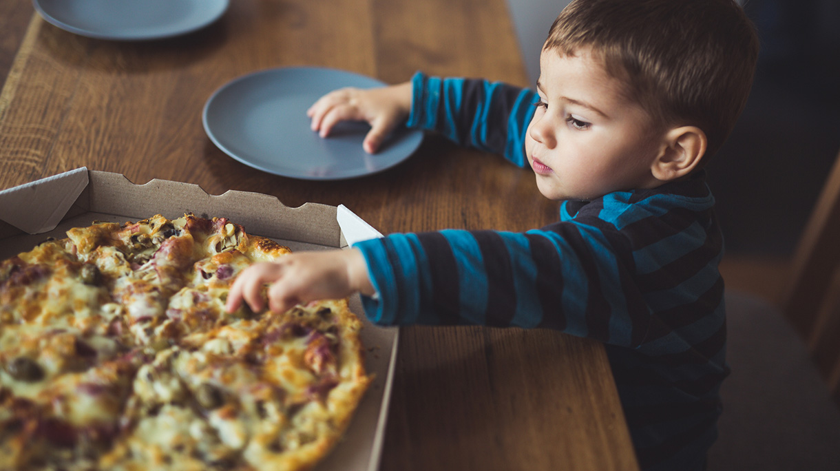 Boy eating pizza at home