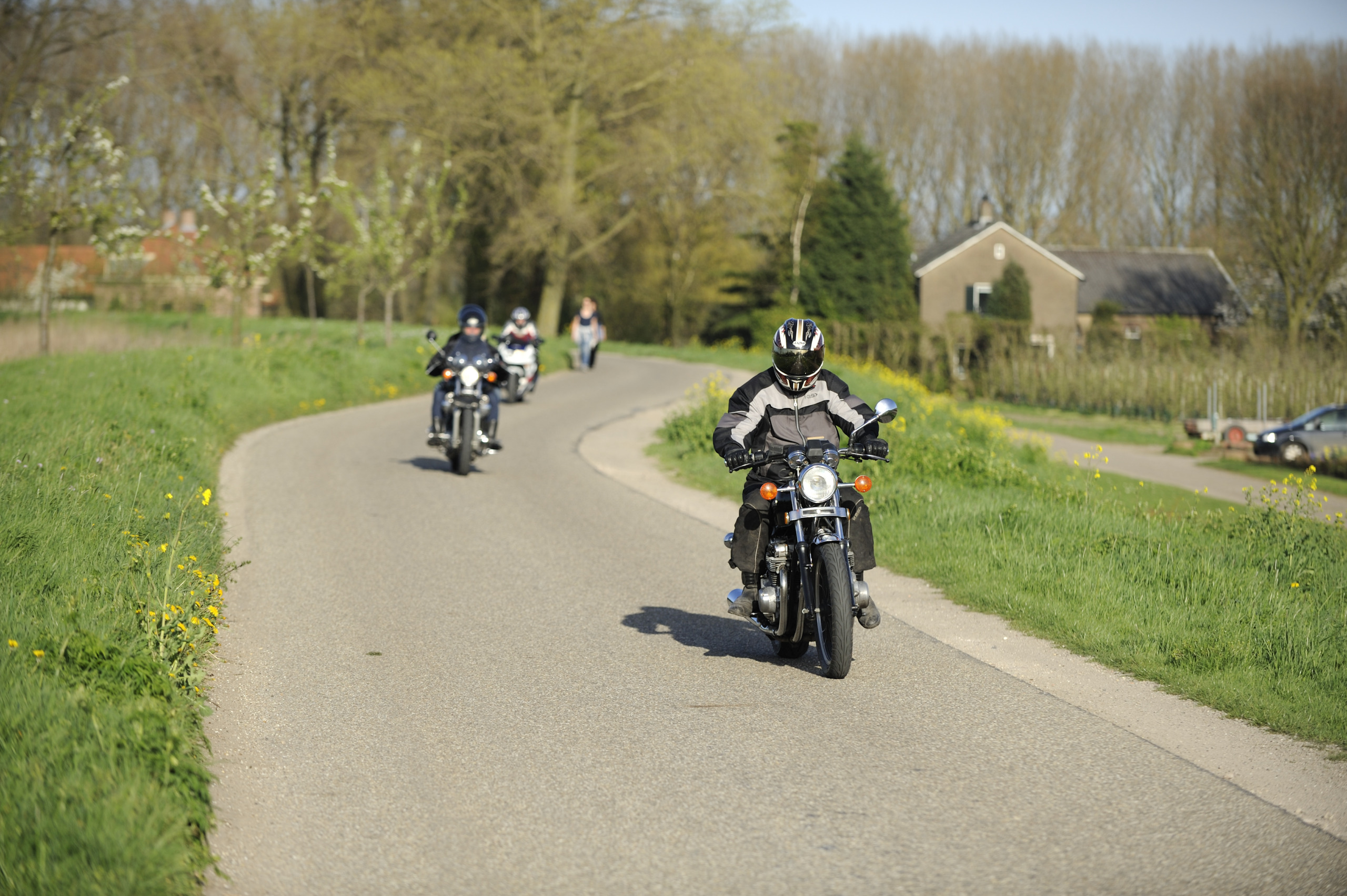 Three motorcyclists on a dyke road in the Netherlands