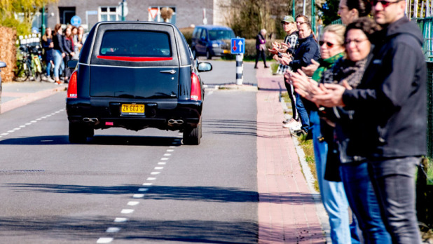 Local residents pay respect as the hearse carrying the