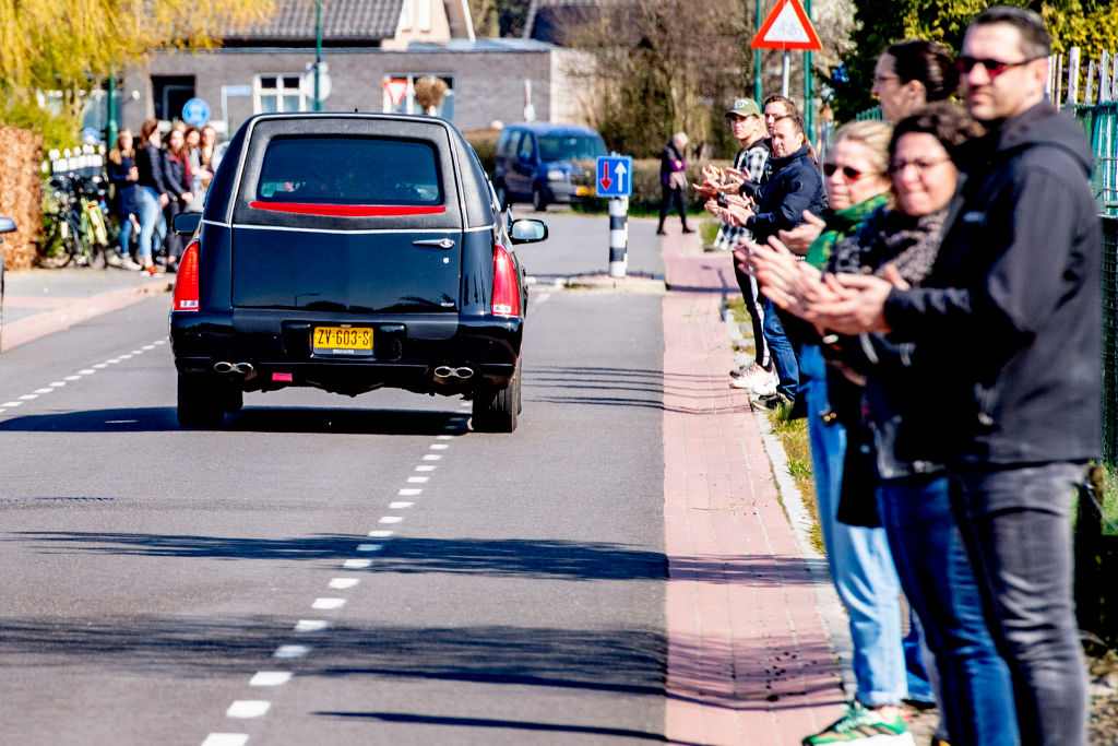 Local residents pay respect as the hearse carrying the