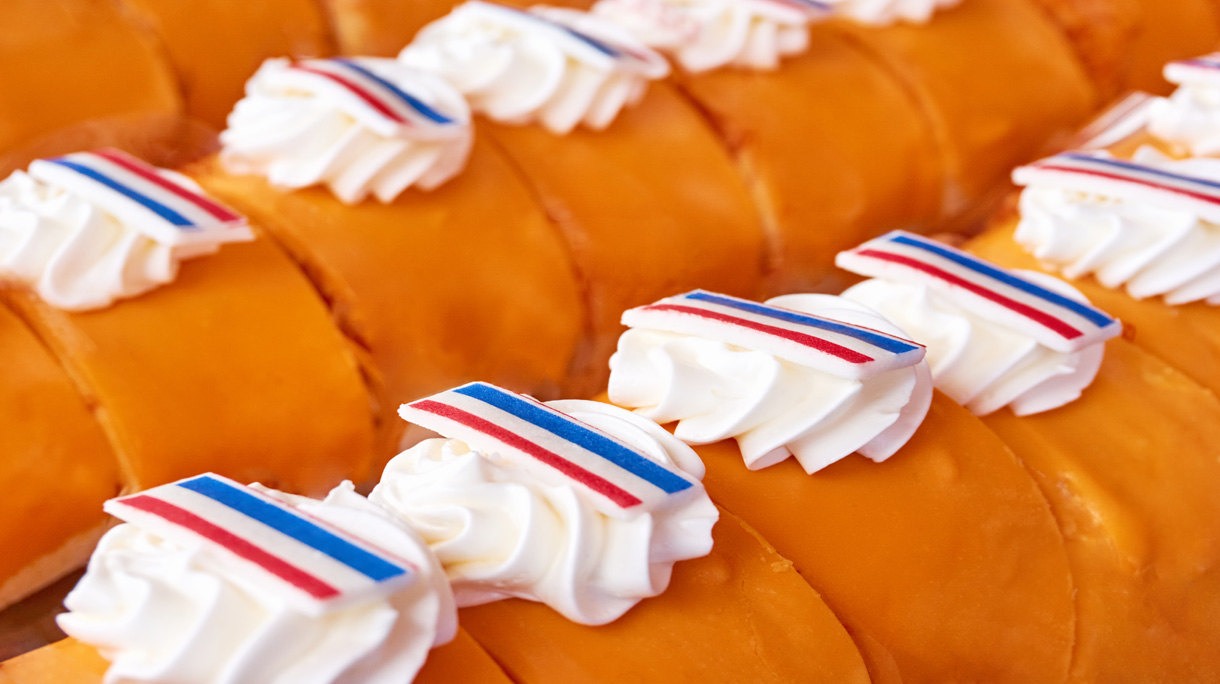 Pastries with orange icing glaze, whipped cream and labels with dutch flags