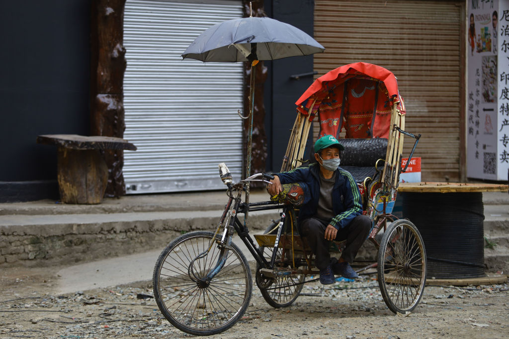 A rickshaw driver waits for tourists despite the nationwide