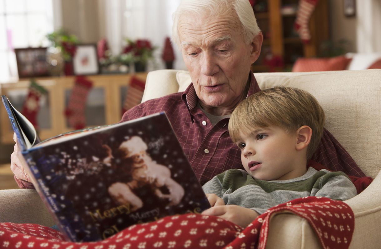 Caucasian grandfather reading book to grandson