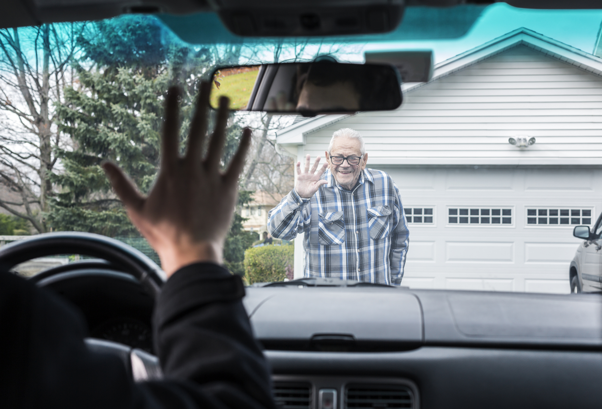 Grandfather and Car Driver Grandson Waving Goodbye Through Windshield