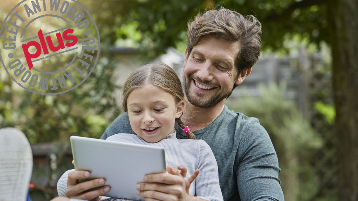 Happy father and daughter using tablet together in garden