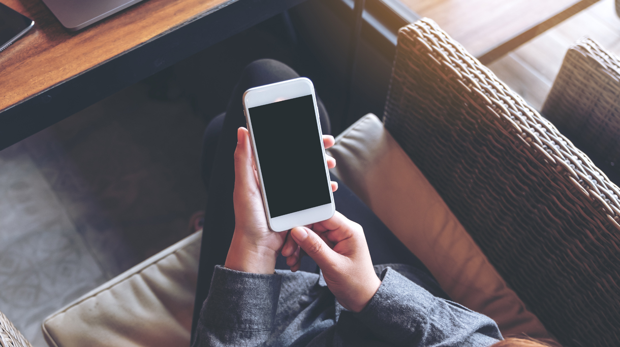 Midsection Of Woman Using Smart Phone In Cafe