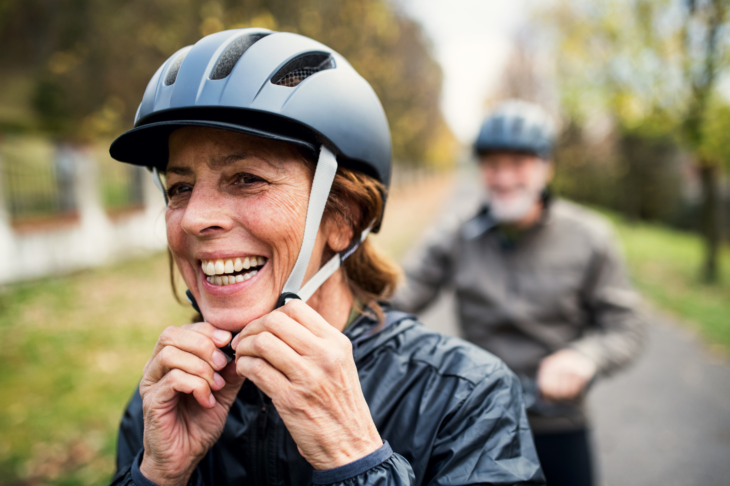Active Senior Couple With Electrobikes Standing Outdoors On A Road In Nature