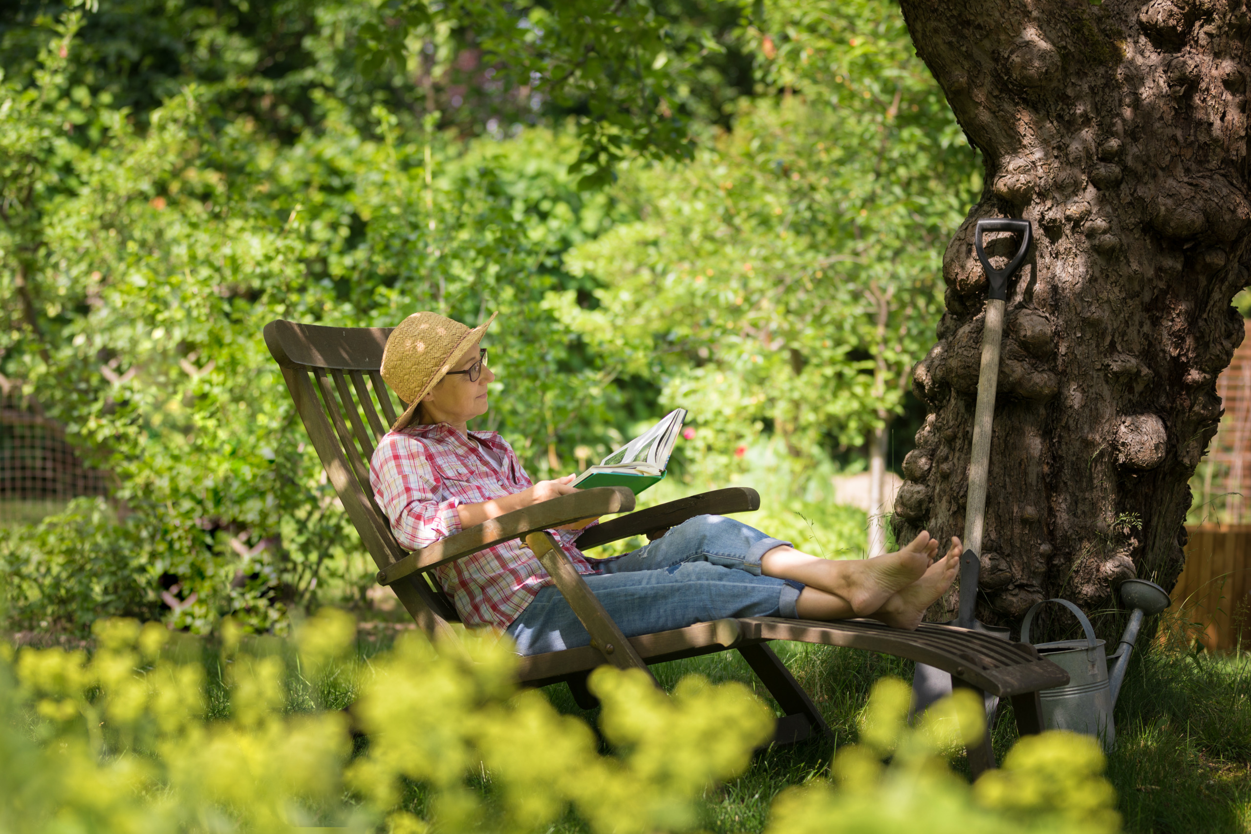 Gardening – senior woman in deck chair enjoy relaxing in garden outdoors