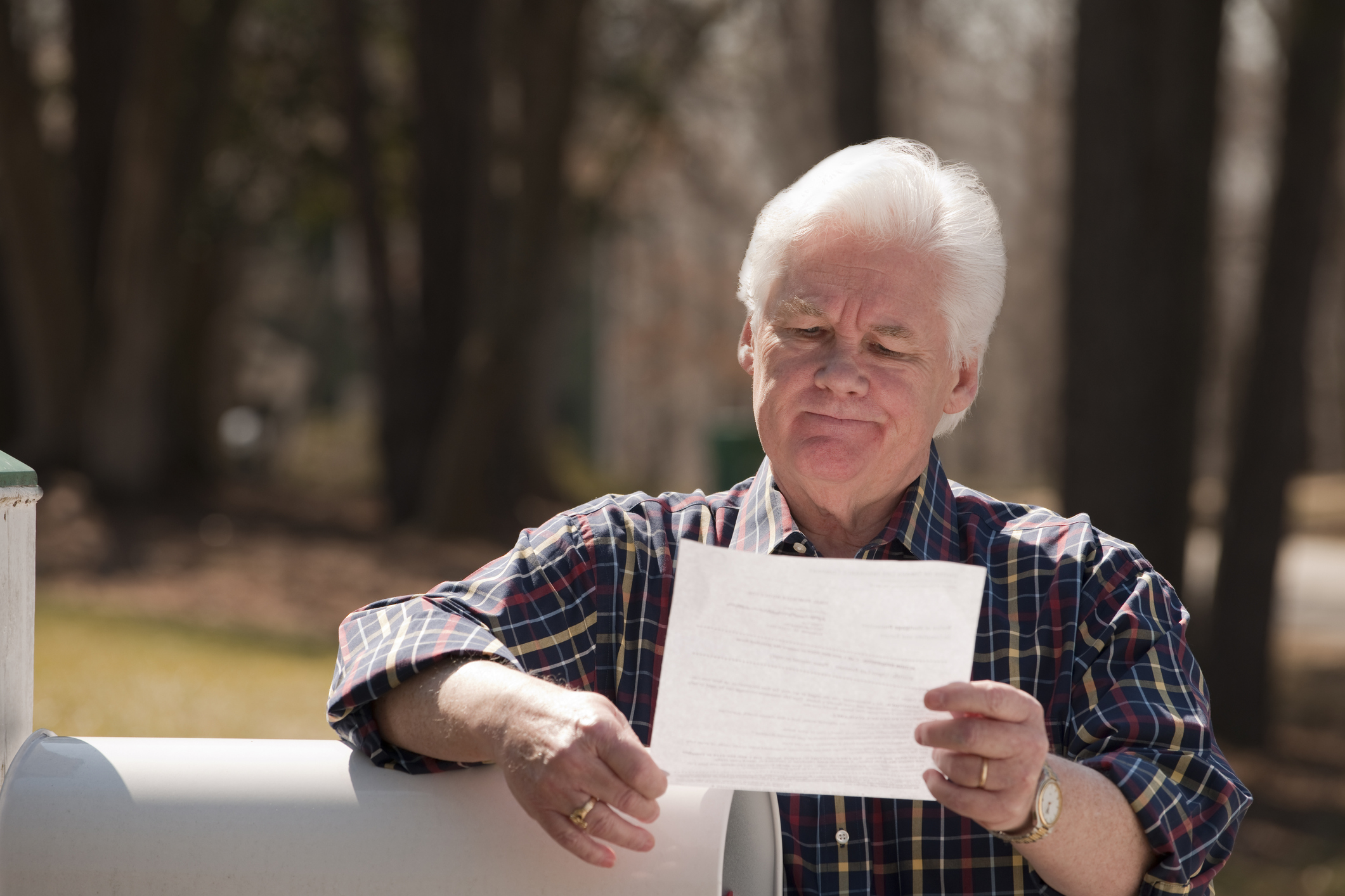 USA, Virginia, Richmond, senior man reading letter by mailbox