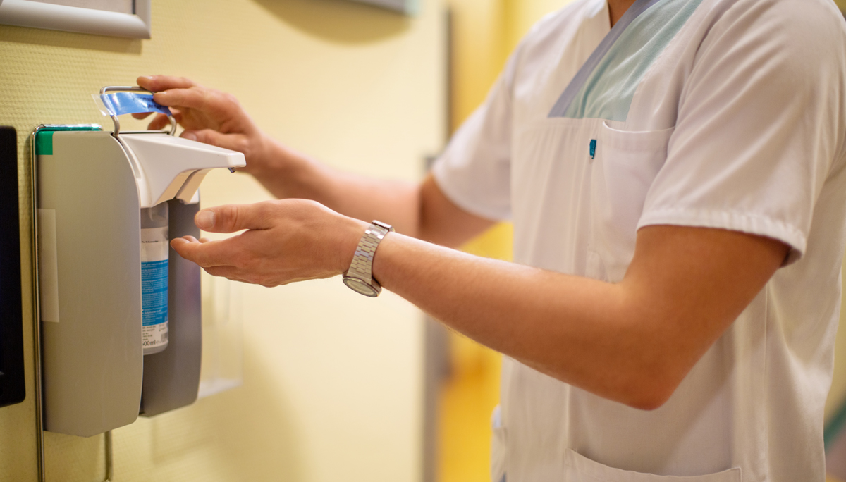 Nurse using anti-bacterial hand sanitizer in clinic