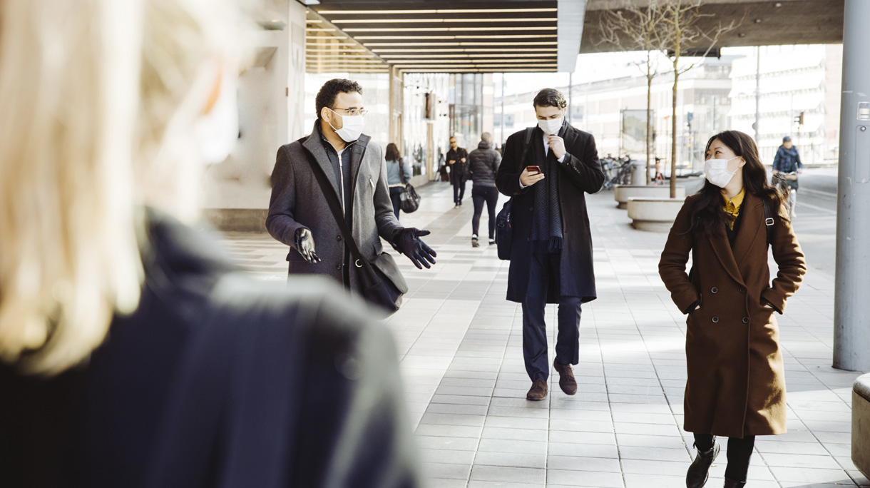 Business people wearing face mask walking in street