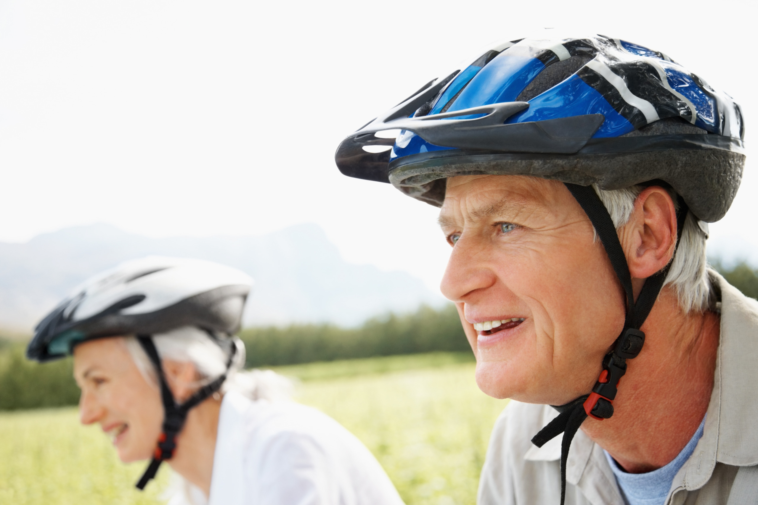 Healthy retired couple enjoying a cycle ride at the fields