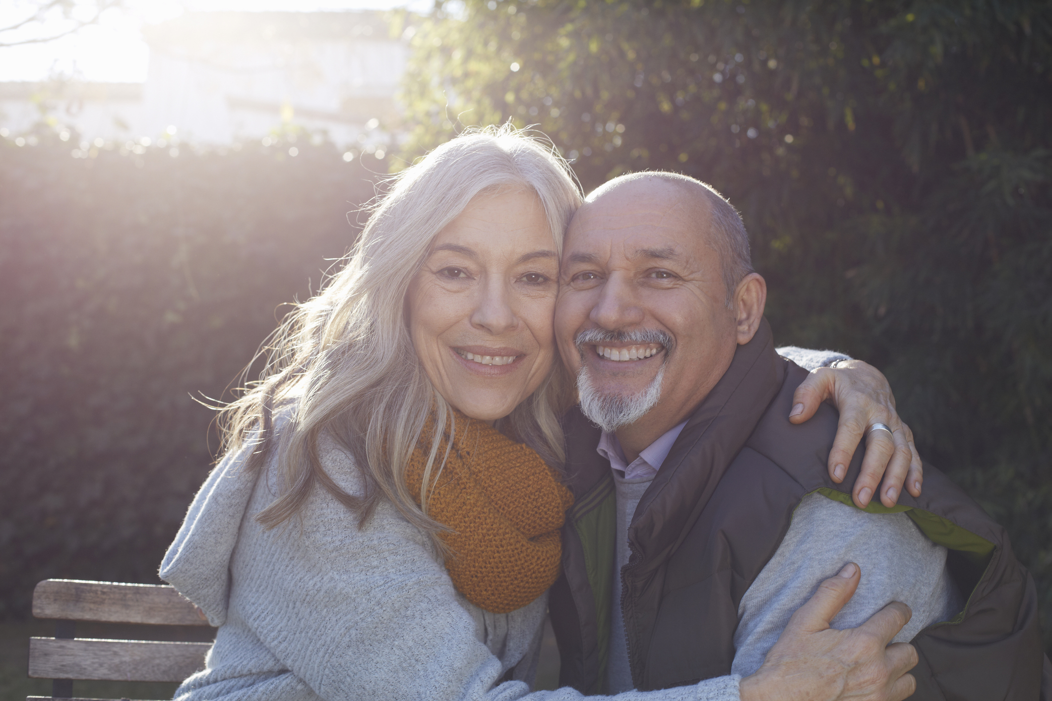 Mature couple hugging, looking at camera smiling
