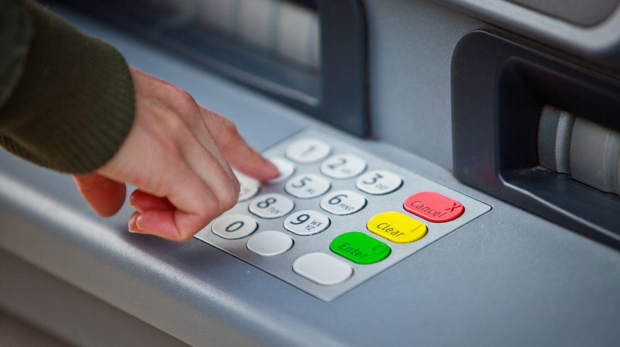 Cropped Hand Of Man Using Atm