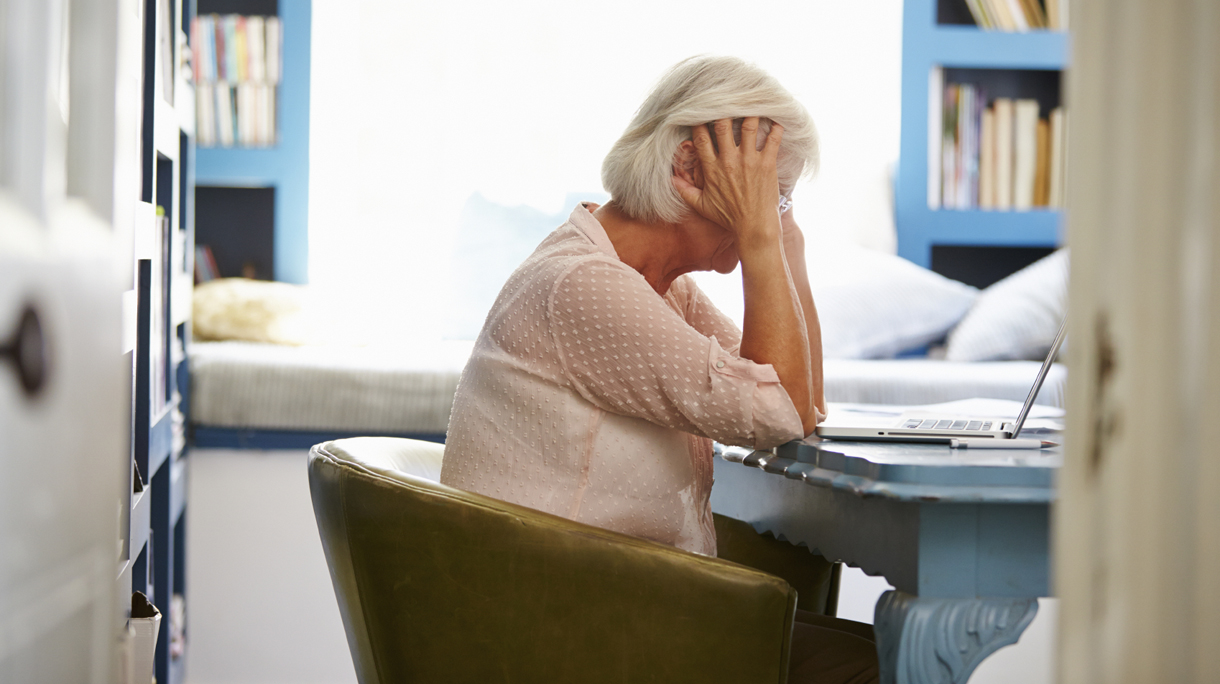 Stressed Senior Woman At Desk In Home Office With Laptop