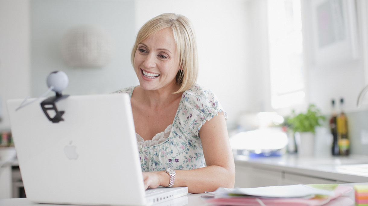 Smiling woman enjoying video chat on laptop