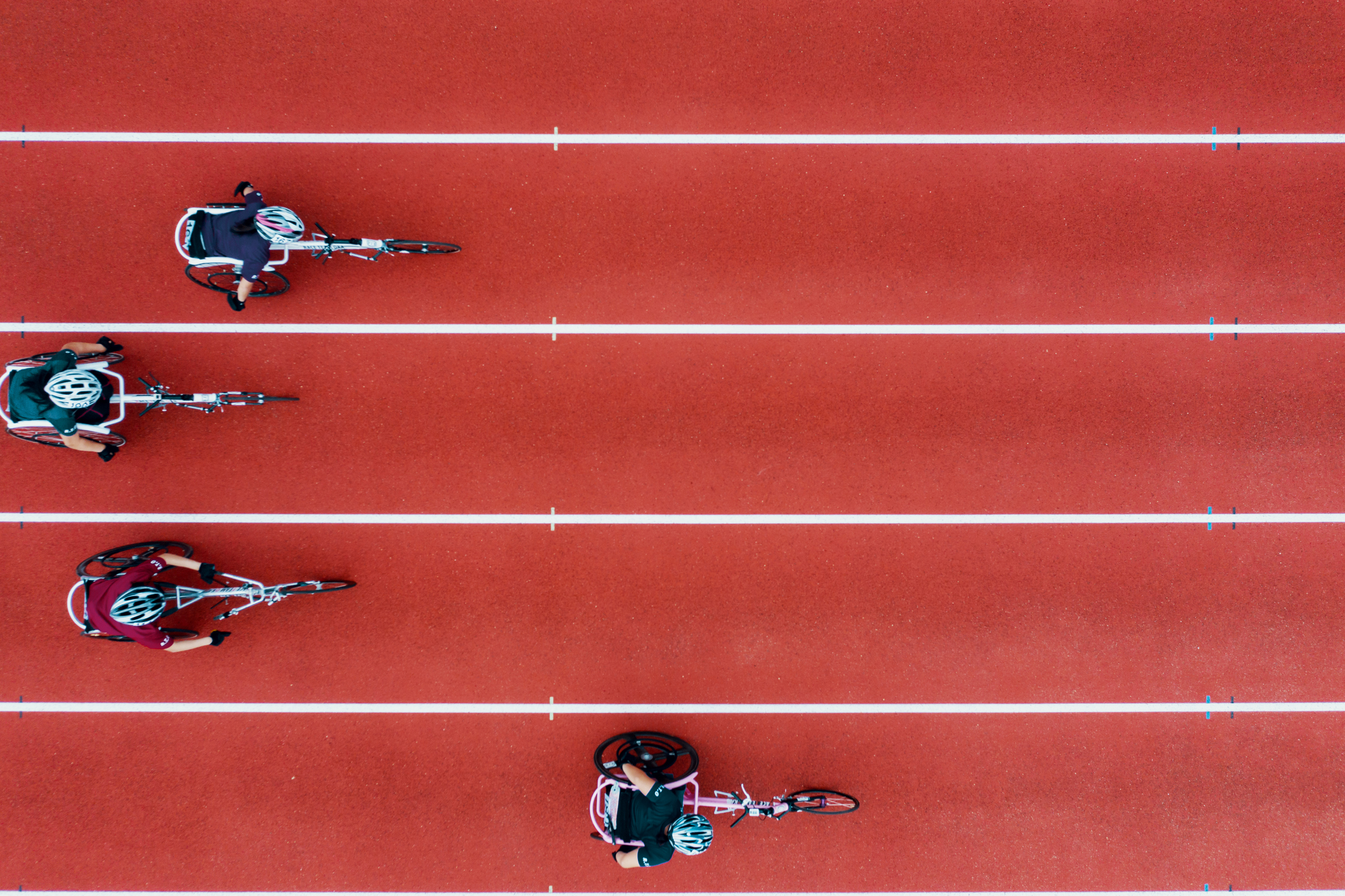 View from directly above four women racing in wheelchairs