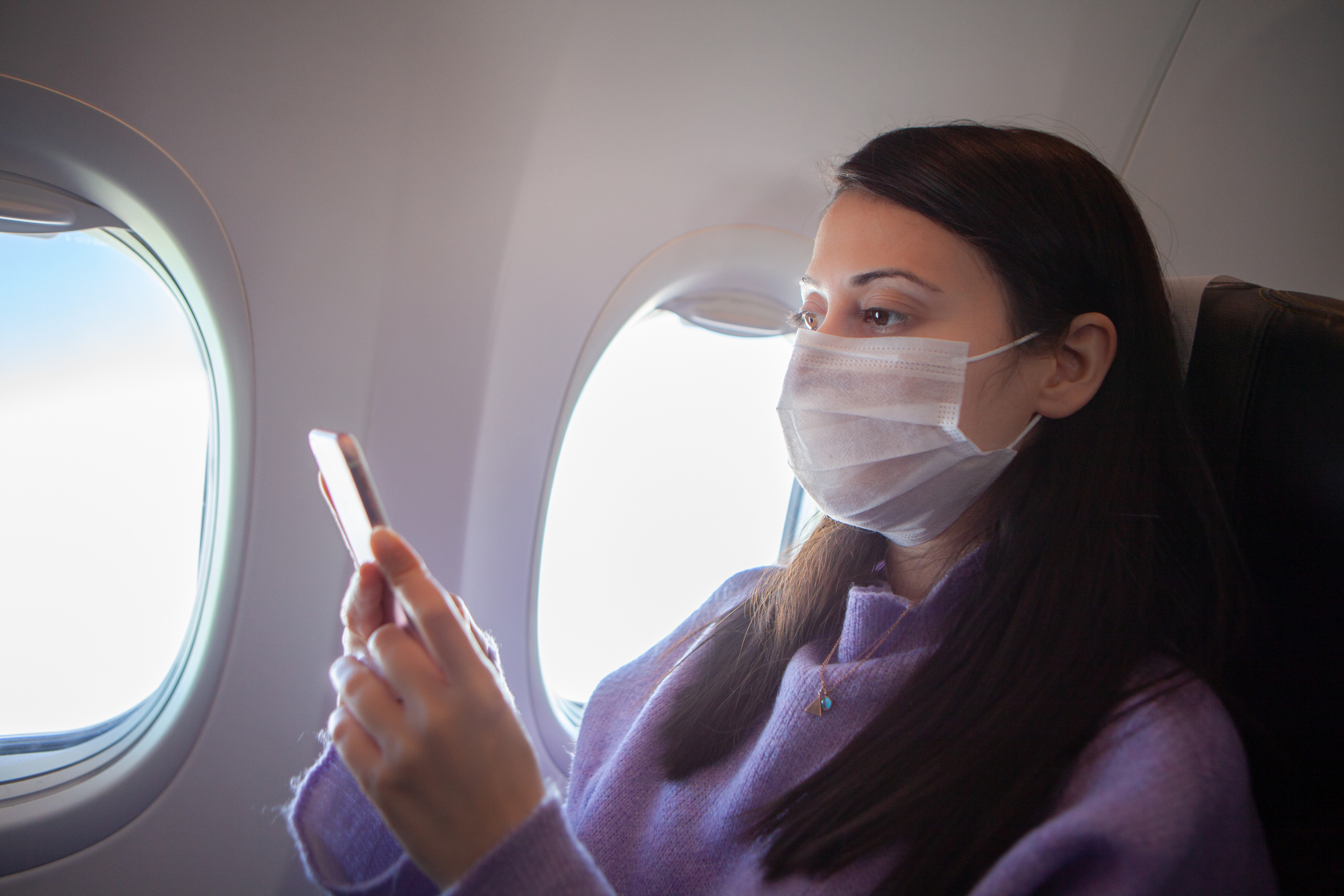 Woman with protective mask in a plane stock photo , coronavirus