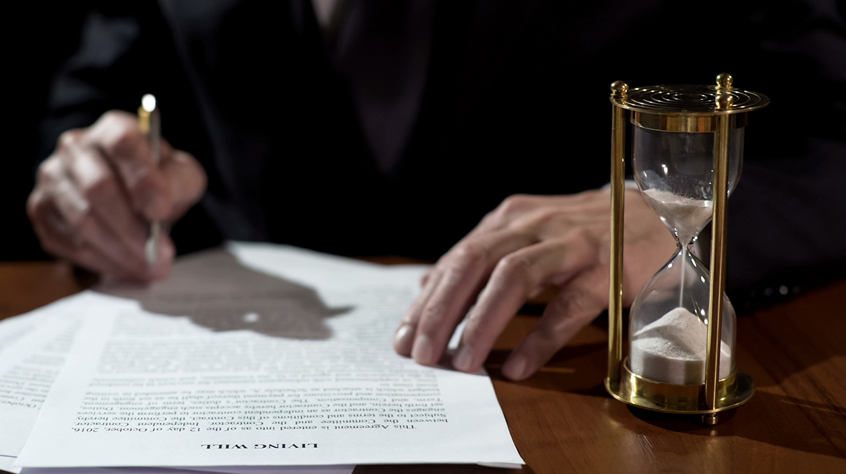 Terminally ill man signing living will before medical care, leaving heritage