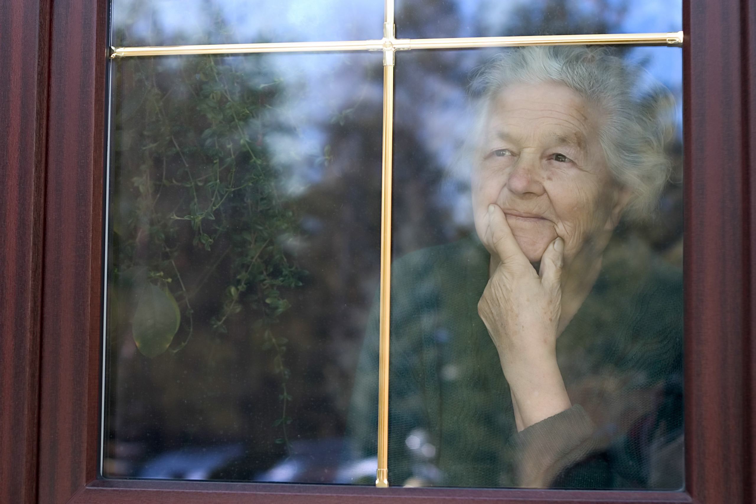 elderly woman looking through the window