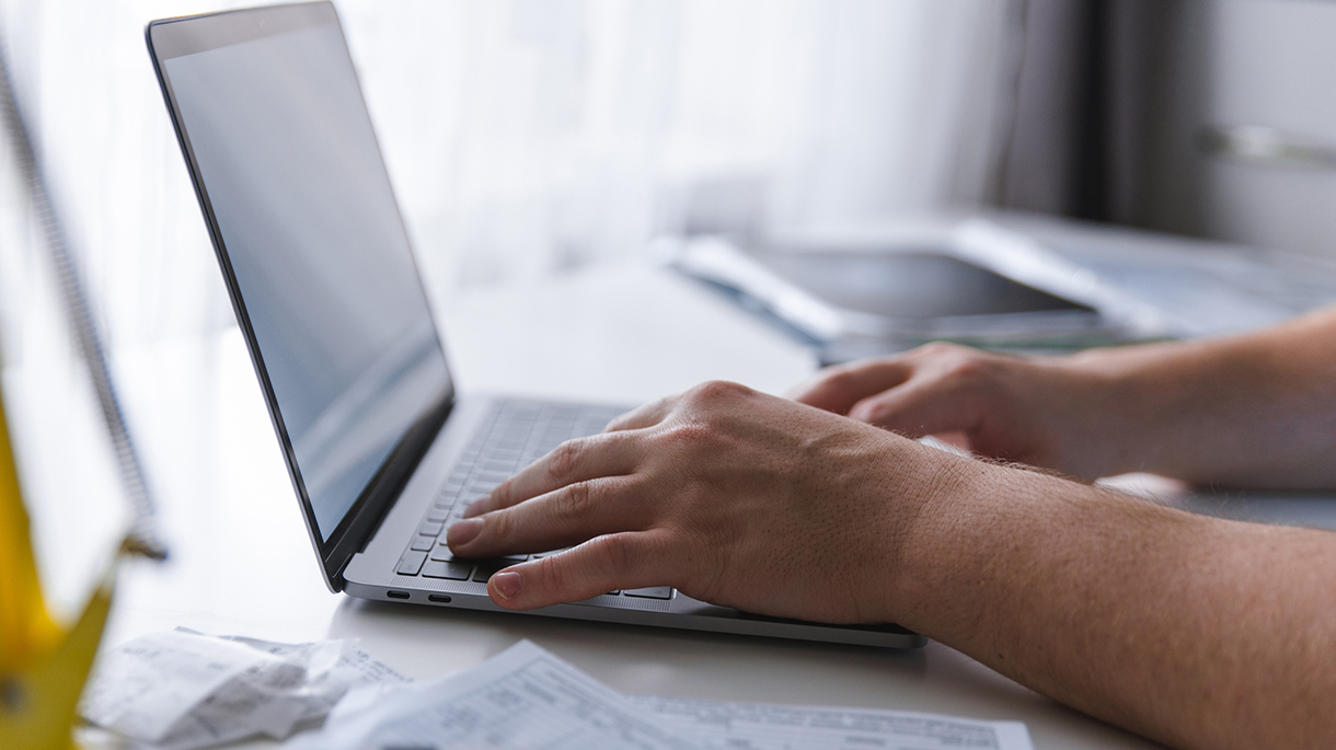 man hands typing on keyboard. laptop with white screen. laptop looks like macbook