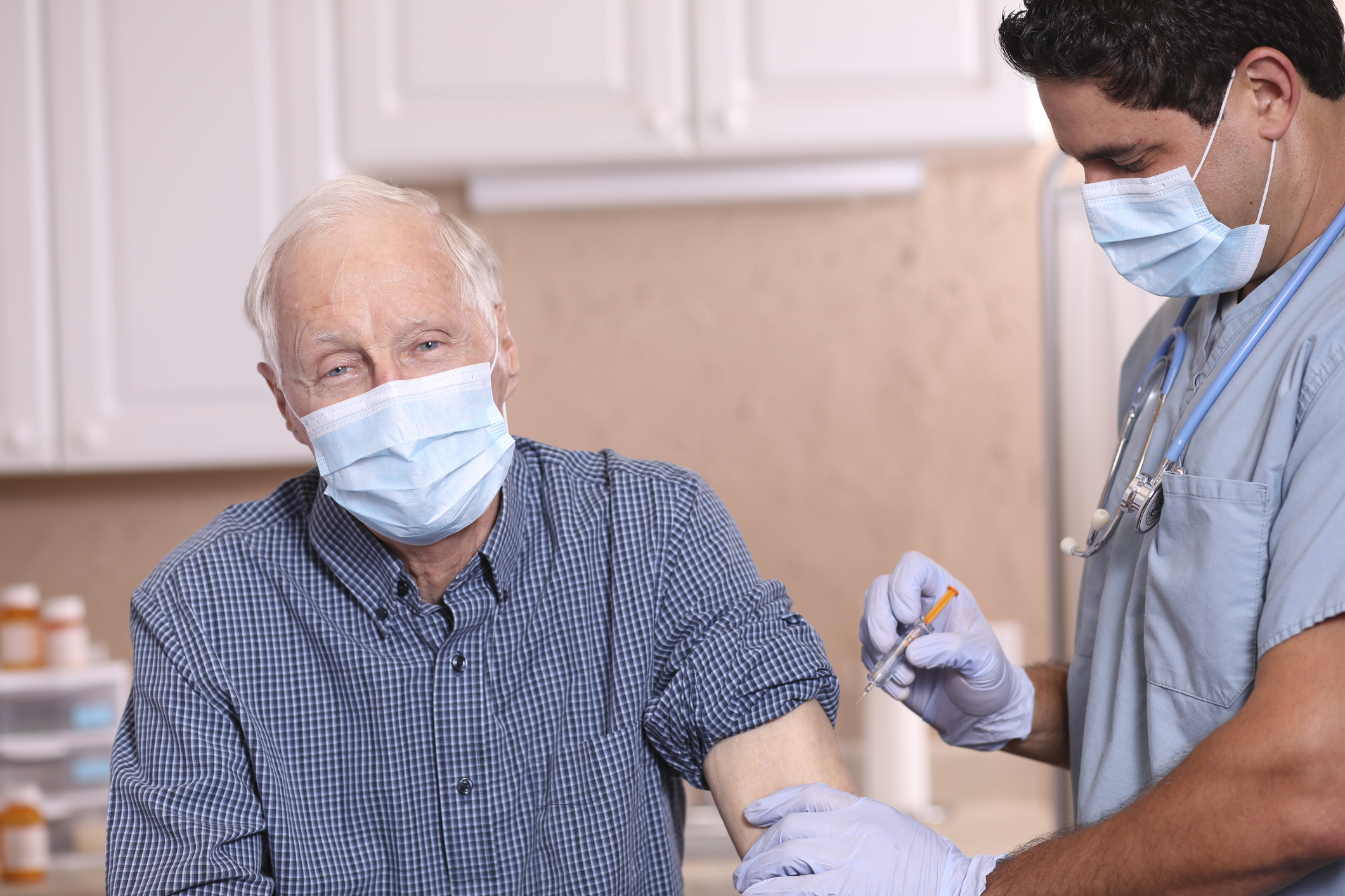 COVID-19: Latin descent doctor and senior adult patient, vaccine, masks.