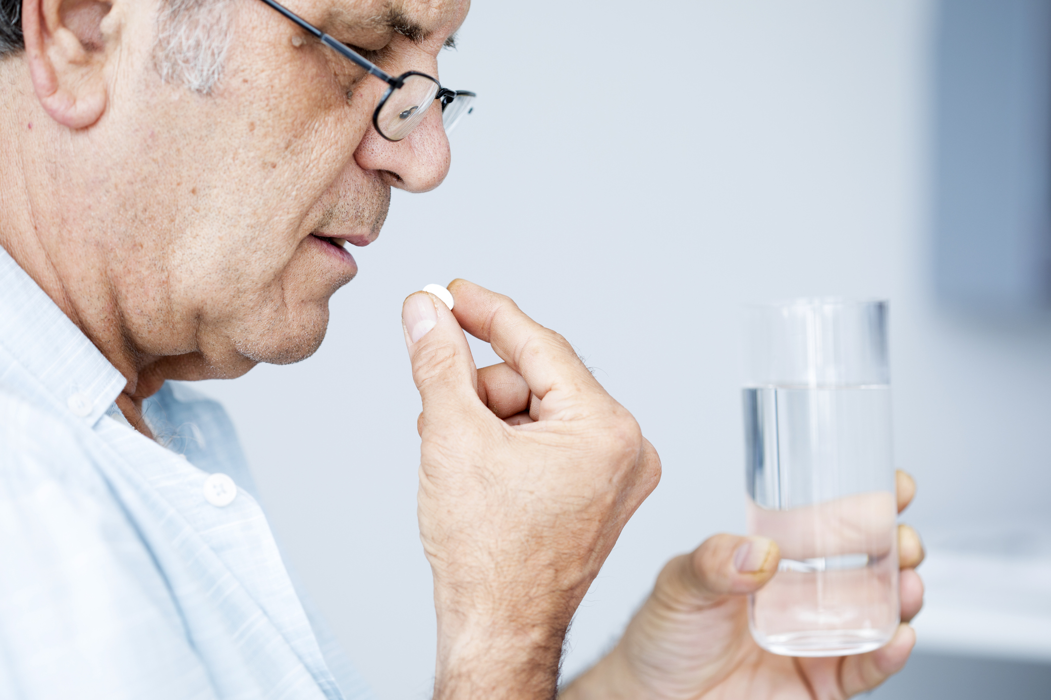 Old man taking a pill