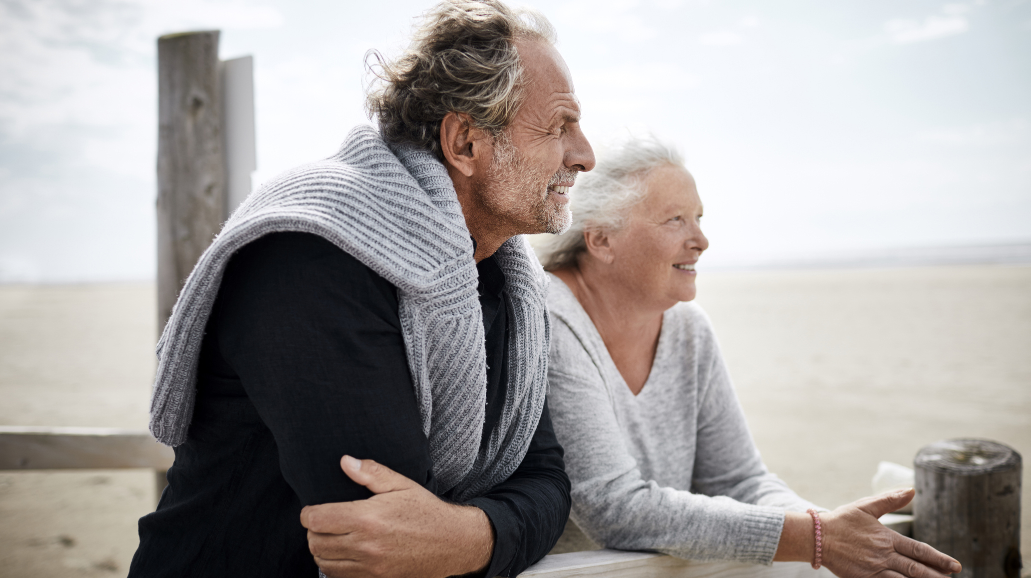 Senior couple standing on boardwalk on the beach