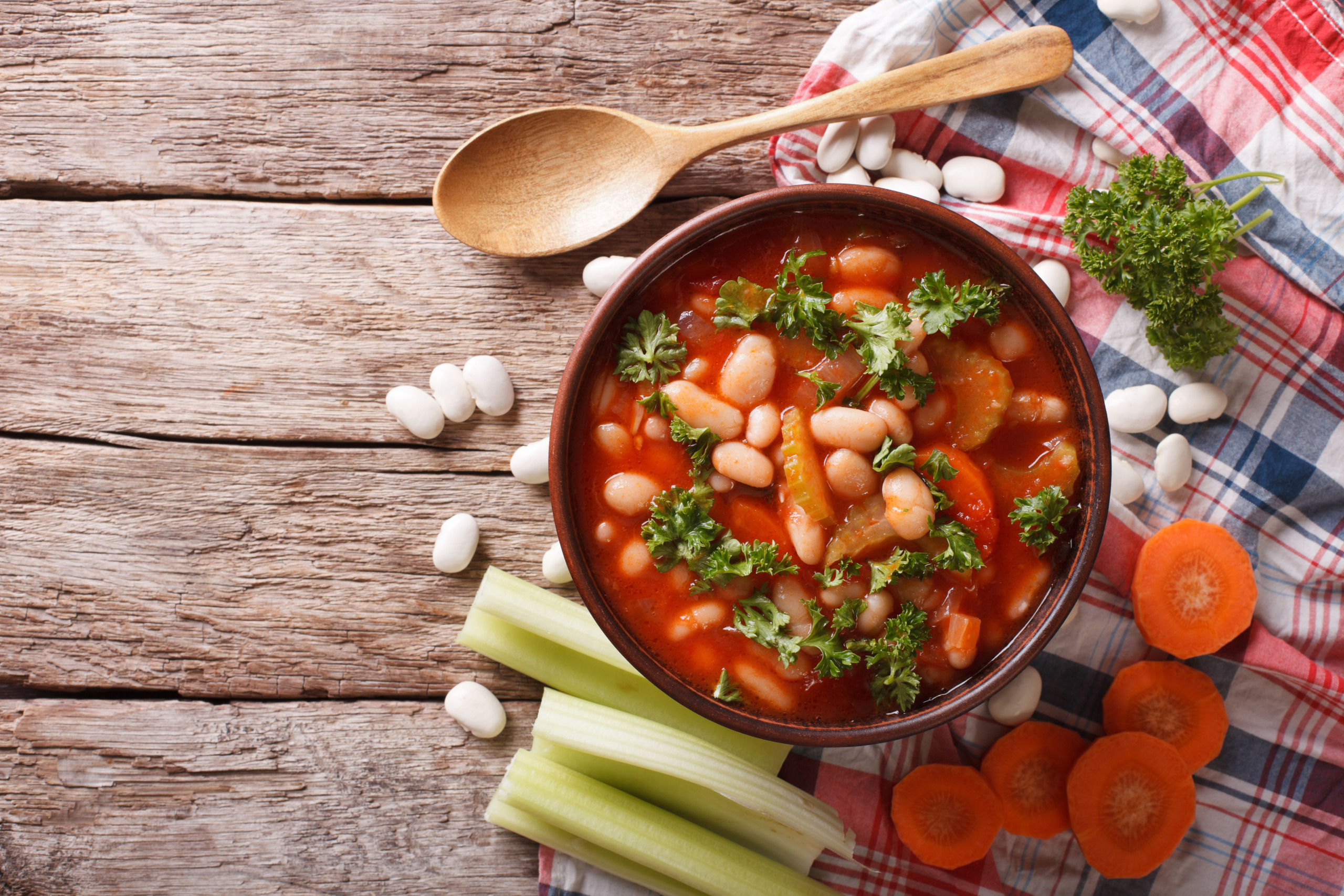 Rustic bean soup with ingredients. horizontal top view