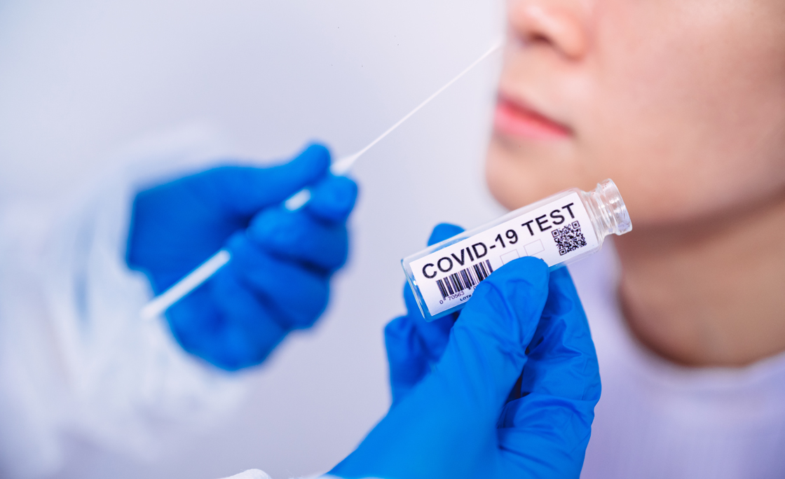 Doctor in protective gloves & workwear holding Testing Kit for the coronavirus test