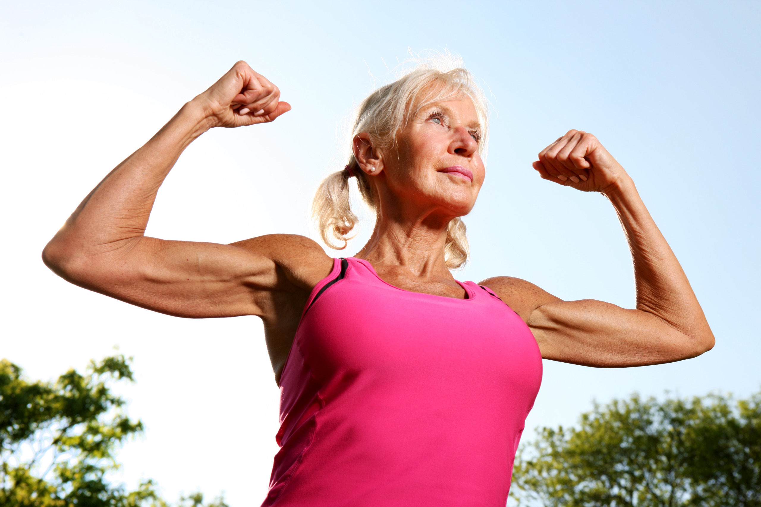 Older woman flexes muscles.