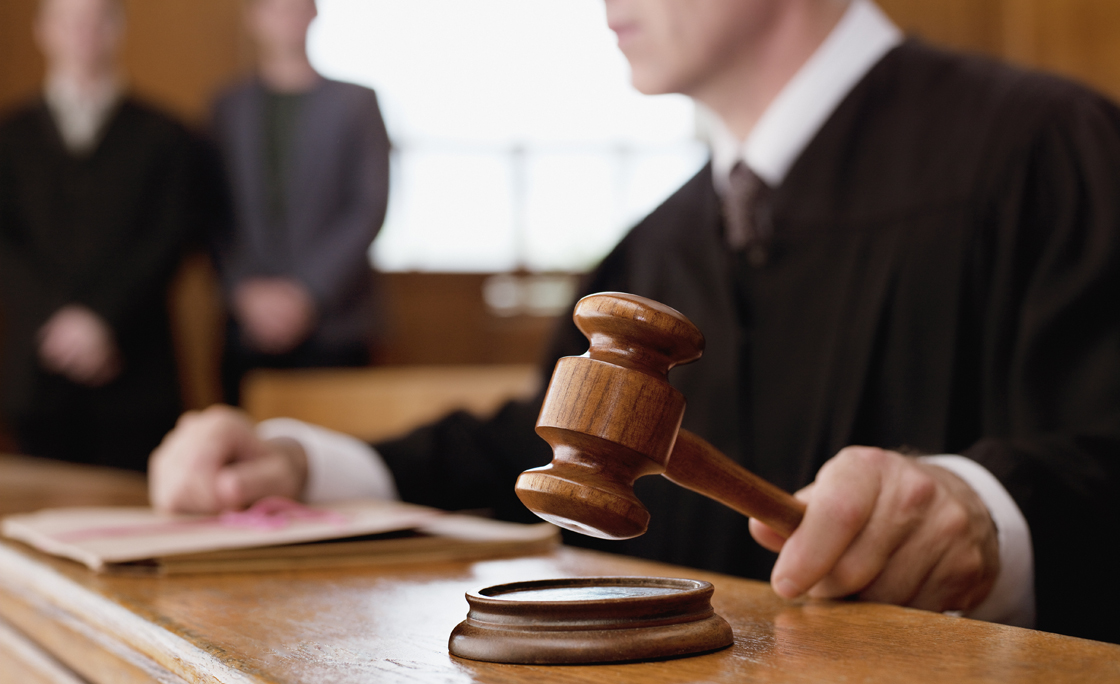 Judge holding gavel in courtroom