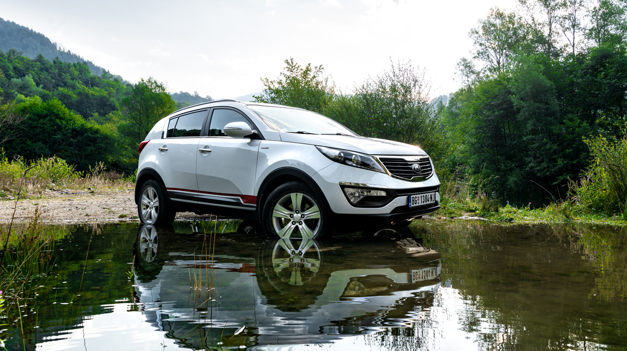 Kia Sportage 2.0 CRDI awd or 4×4, white color,  crossing a lake Lazici, on mountain Tara, near a big cliff, and beautifull countryside, in deep mud wheel spin, great off road
