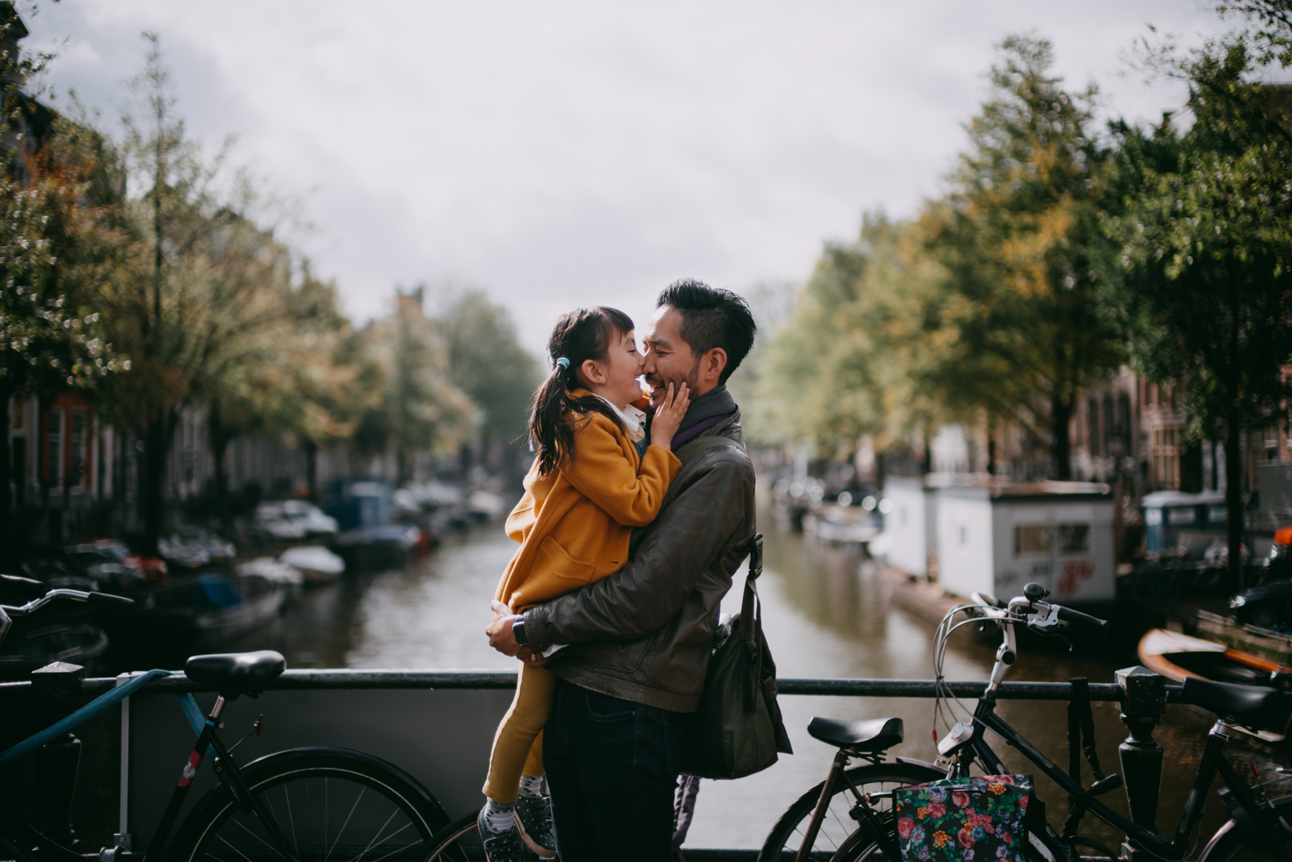 Father holding child on bridge over canal in Amsterdam