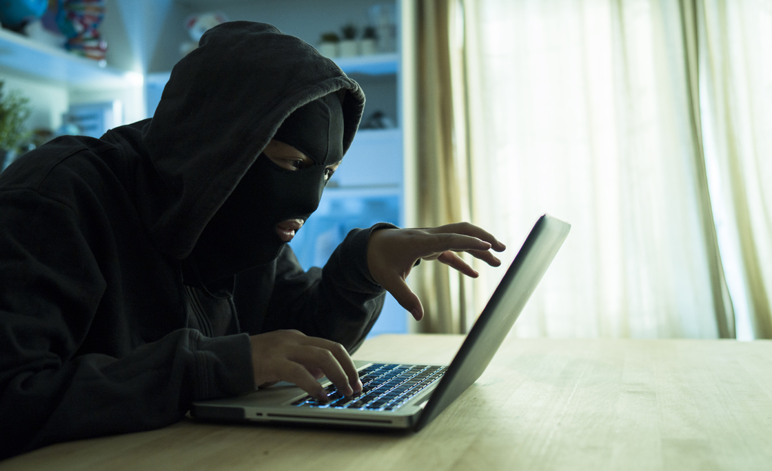 Computer hacker stealing information with laptop